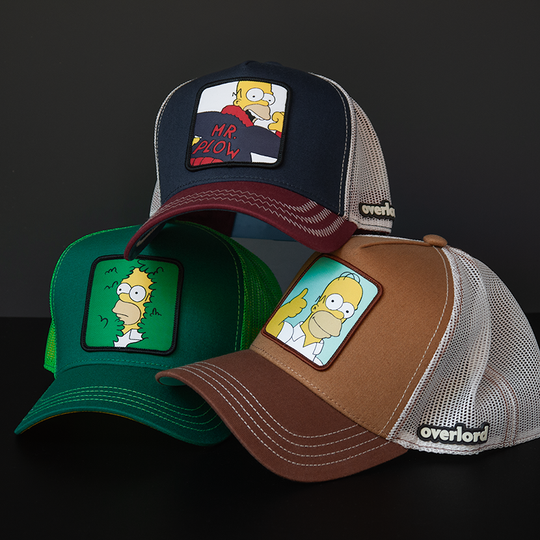 Green OVERLORD X The Simpsons present Homer in bush trucker baseball cap hat with green stitching. PVC Overlord logo.