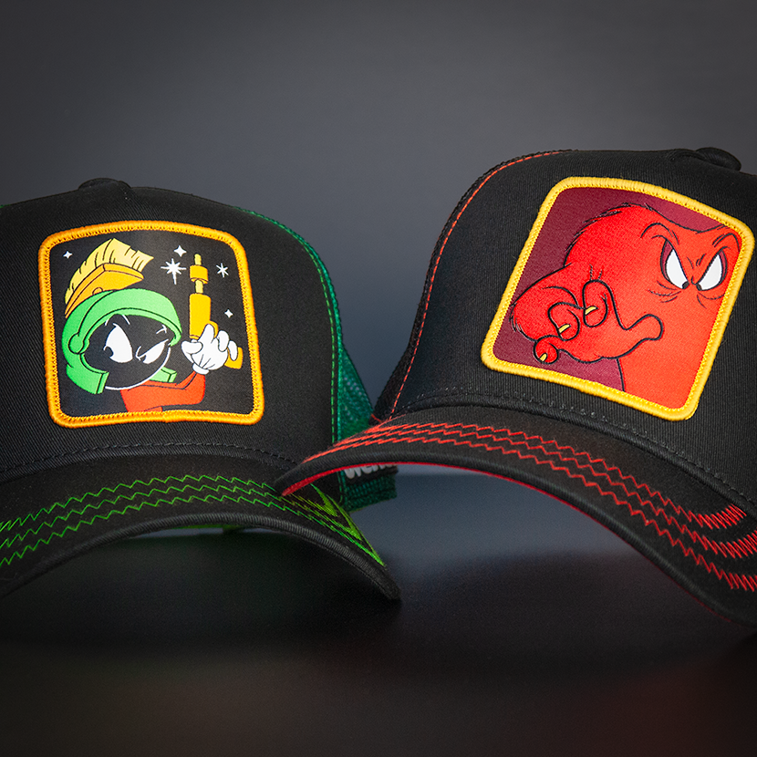 Black OVERLORD X Looney Tunes Gossamer trucker baseball cap hat with red zig zag stitching. PVC Overlord logo.
