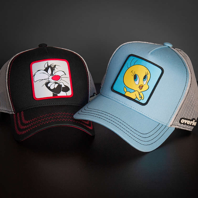 Black OVERLORD X Looney Tunes smug Sylvester the cat trucker baseball cap hat with red zig zag stitching. PVC Overlord logo.