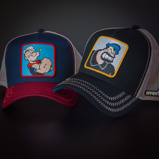 Navy and red OVERLORD X Popeye smug Popeye trucker baseball cap hat with red zig zag stitching. PVC Overlord logo.