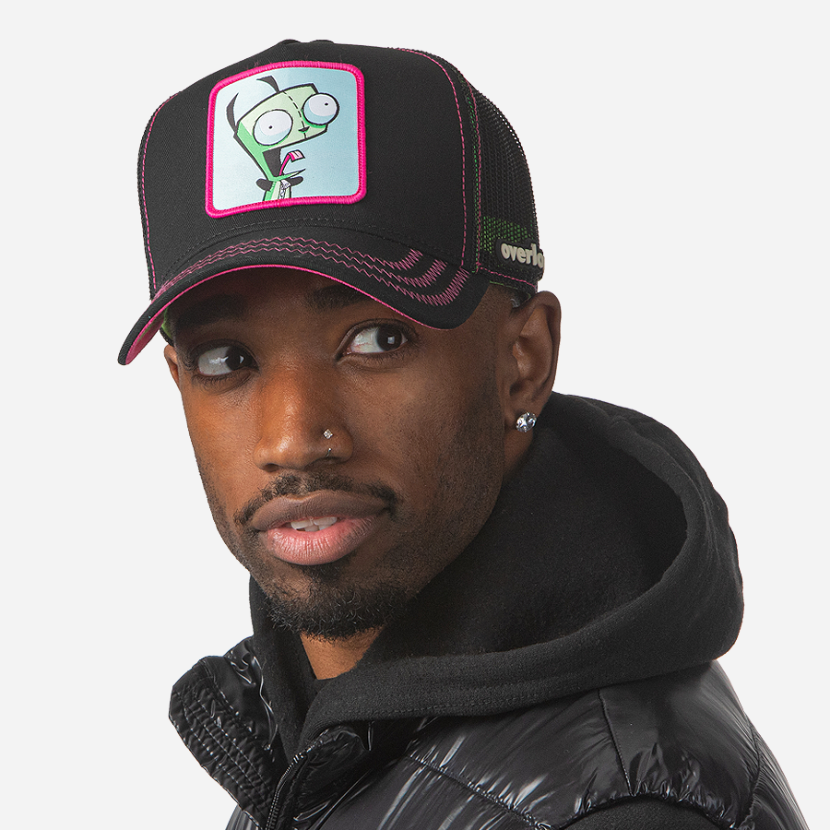 Man wearing black OVERLORD X Invader Zim yeliing GIR trucker baseball cap hat with hot pink zig zag stitching. PVC Overlord logo.