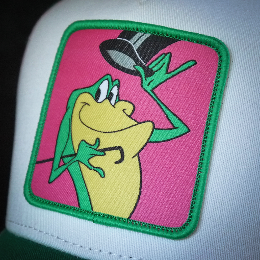White and green OVERLORD X Looney Tunes Michigan J. Frog trucker baseball cap hat woven Overlord patch closeup.