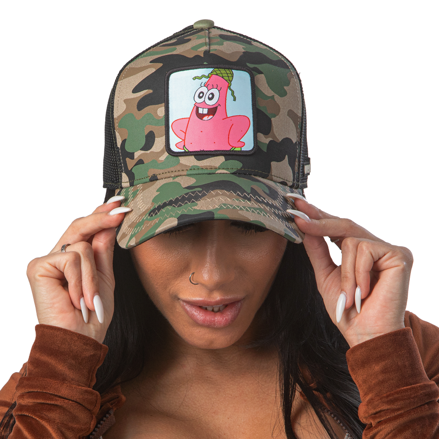 Woman wearing camo OVERLORD X SpongeBob Private Patrick trucker baseball cap hat with khaki zig zag stitching. PVC Overlord logo.