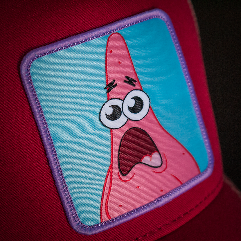 Brick red OVERLORD X SpongeBob Patrick surprised face trucker baseball cap woven Overlord patch closeup.