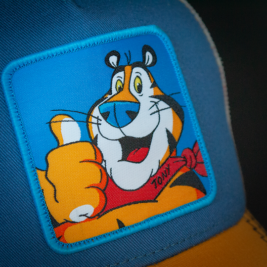 Blue OVERLORD X Kelloggs Tony Tiger Frosted Flakes trucker baseball cap hat woven Overlord patch closeup.