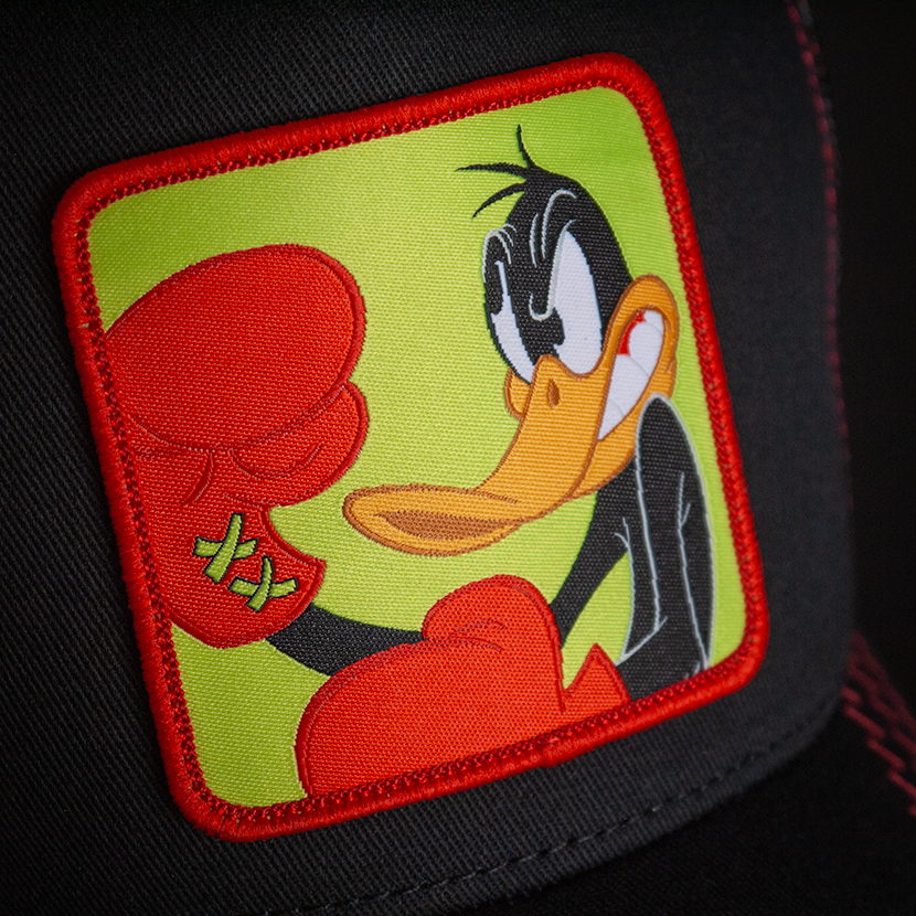 Black OVERLORD X Looney Tunes Daffy Duck in boxing gloves trucker baseball cap hat woven Overlord patch closeup.