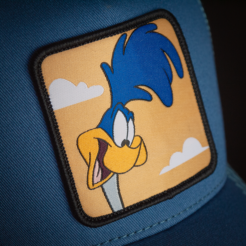 Blue OVERLORD X Looney Tunes smiling Road Runner trucker baseball cap hat woven Overlord patch closeup.