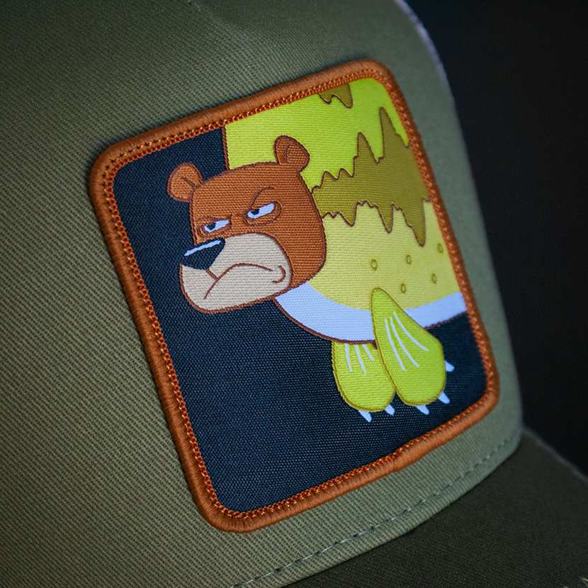 Olive green OVERLORD X SpongeBob Seabear trucker baseball cap hat woven Overlord patch closeup.