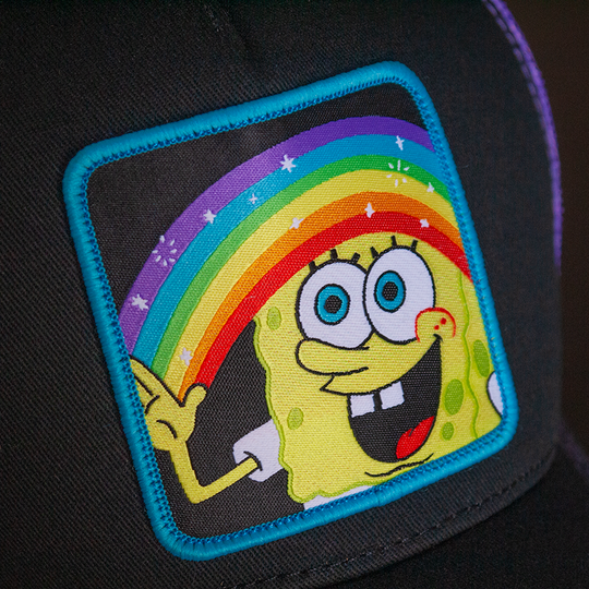 Black OVERLORD X SpongeBob Imagination SpongeBob holding a rainbow trucker baseball cap hat woven Overlord patch closeup.