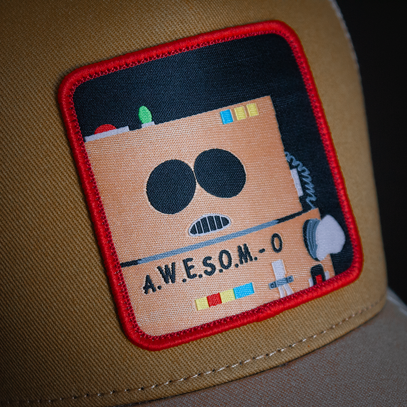 Tan OVERLORD X South Park A.W.E.S.O.M-O robot trucker baseball cap hat woven Overlord patch closeup.