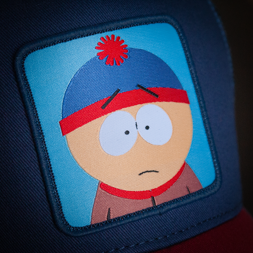 Navy and red OVERLORD X South Park Stan trucker baseball cap hat woven Overlord patch closeup.