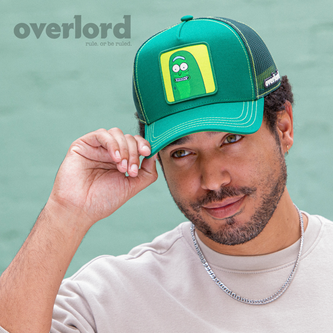 Man wearing dark Green OVERLORD X Rick & Morty scared Pickle Rick trucker baseball cap hat with lime green stitching. PVC Overlord logo.