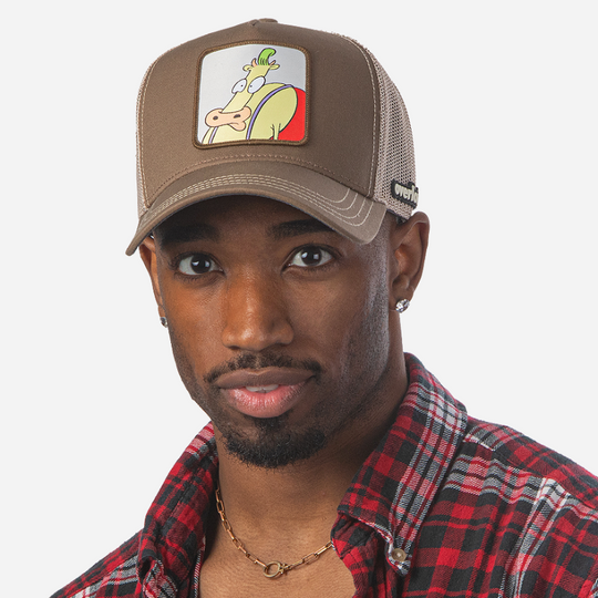 Man wearing dark tan OVERLORD X Rocko's Modern Life Heffer Wolfe trucker baseball cap hat with khaki stitching. PVC Overlord logo.