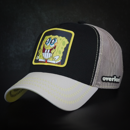 Black and tan OVERLORD X SpongeBob Big Smile SpongeBob trucker baseball cap hat with yellow zig zag stitching. PVC Overlord logo.