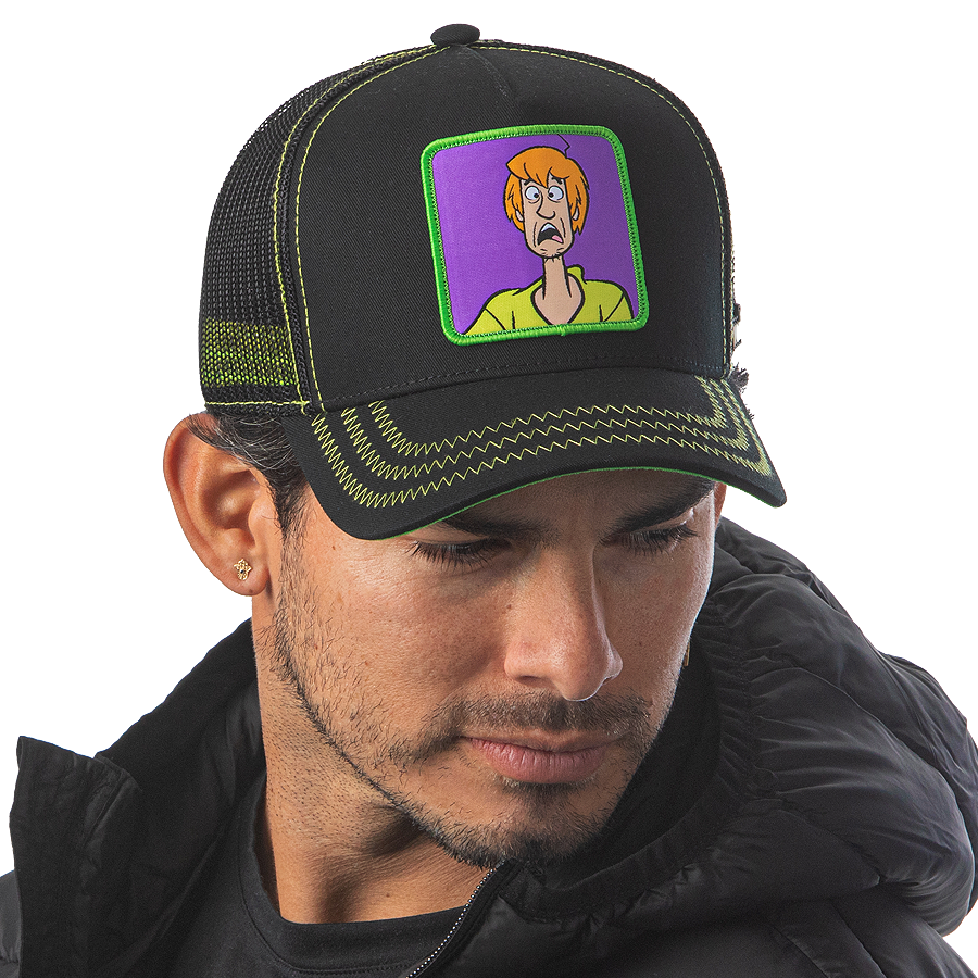 Man wearing black OVERLORD X Scooby-Doo scared Shaggy trucker baseball cap hat with lime green zig zag stitching. PVC Overlord logo.