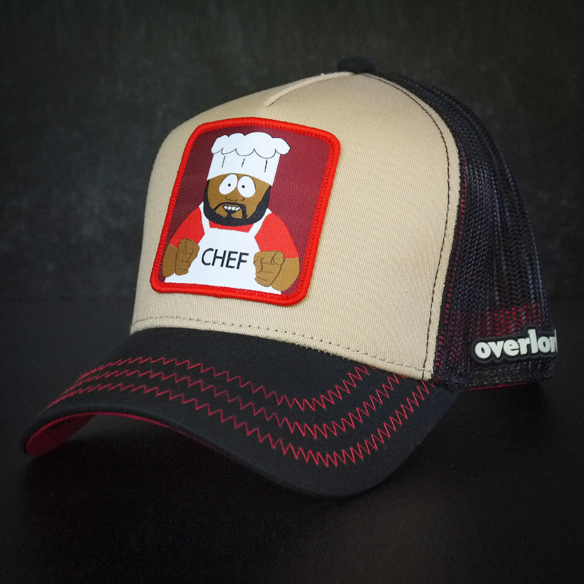 Tan and black OVERLORD X South Park Chef trucker baseball cap hat with red zig zag stitching. PVC Overlord logo.