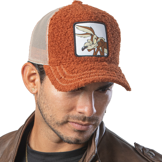 Man in brown leather jacket wearing brown sherpa OVERLORD X Looney Tunes Wile E. Coyote trucker baseball cap hat.
