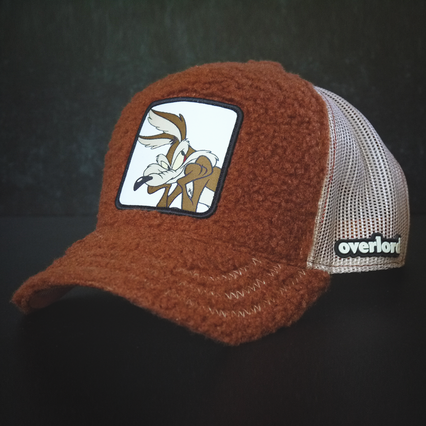 Brown sherpa OVERLORD X Looney Tunes Wile E. Coyote trucker baseball cap hat with khaki zig zag stitching. PVC Overlord logo.
