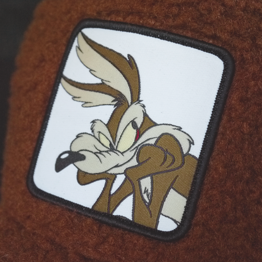 Brown sherpa OVERLORD X Looney Tunes Wile E. Coyote trucker baseball cap hat woven Overlord patch closeup.